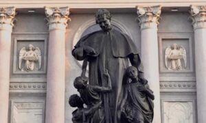 Estatua En Honor A Don Bosco Donde El Santo Juega Con Unos Niños