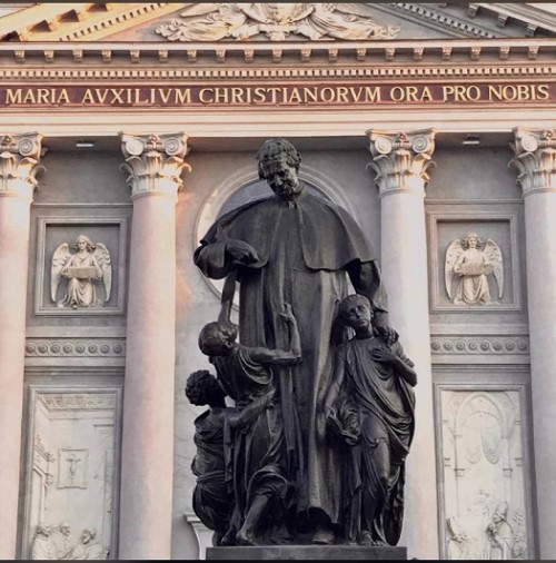 Estatua En Honor A Don Bosco Donde El Santo Juega Con Unos Niños