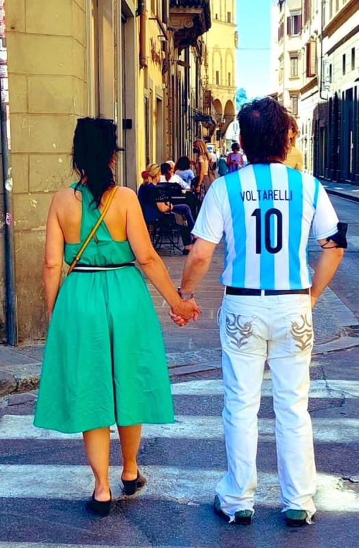 Peppe Voltarelli caminando por Italia con una camiseta argentina con el número 10 y su apellido. De la mano de su pareja Anna Corcione