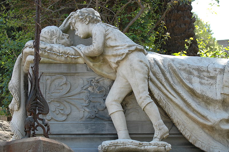 Mariette la piccola inquieta di Viale del Fossario. Cimitero Monumentale di Bonaria Cagliari. In primo piano una tomba raffigurante un bambino che bacia la madre morente.