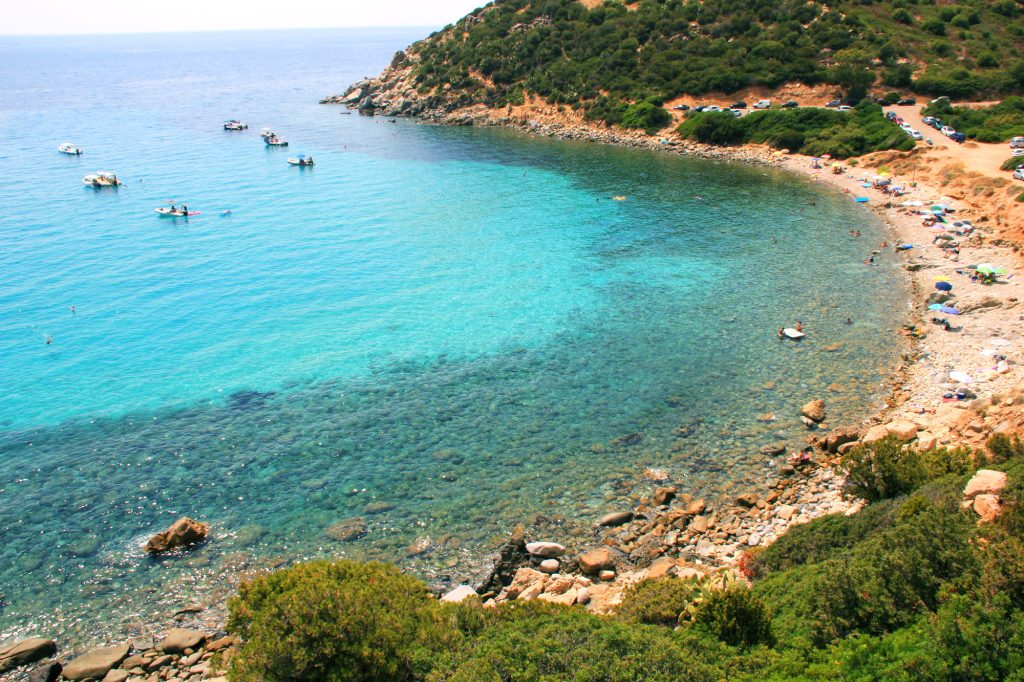 Tempo di mare e le spiagge di Cagliari e dintorni. La Spiaggia di Cala Regina. La foto prende una parte della spiaggia con in lontananza alcune barche.