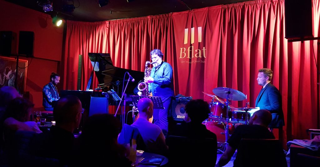 Bflat il cuore della musica Jazz di Cagliari. Concerto con il sax di Emanuele Cisi che si vede in primo piano, insieme alla sua band di musicisti.