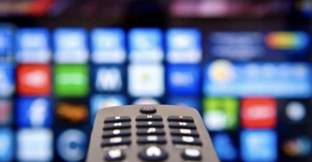 Digitale terrestre 2021 si cambia (Ancora). Digitale Terrestre.Nella foto vediamo in primo piano un telecomando con nello sfondo un televisore sfuocato