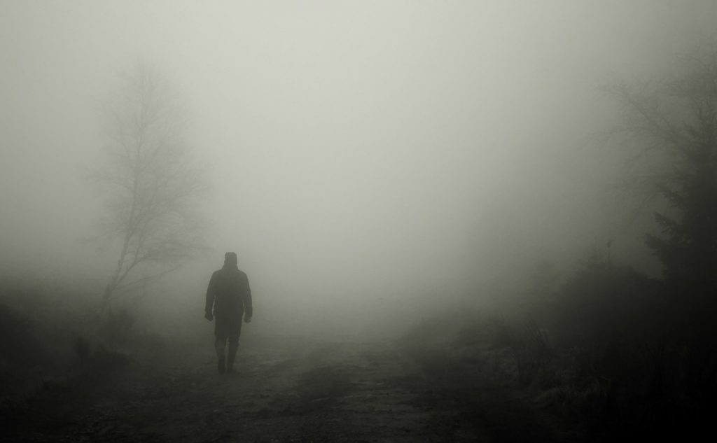 Mommotti - Un uomo vestito di nero che vaga nella nebbia