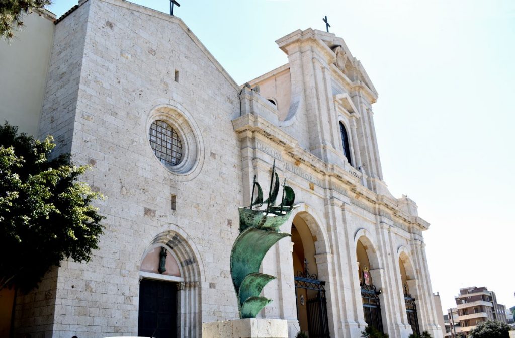 Primo piano della facciata del Santuario e Basilica della Nostra Signora di Bonaria con statua in primo piano