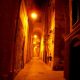 una via cittadina durante la notte appena illuminata dai lampioni Cagliari Dei Misteri