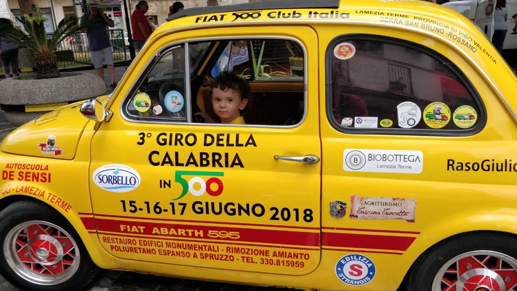 un bambino all'interno di una 500 gialla