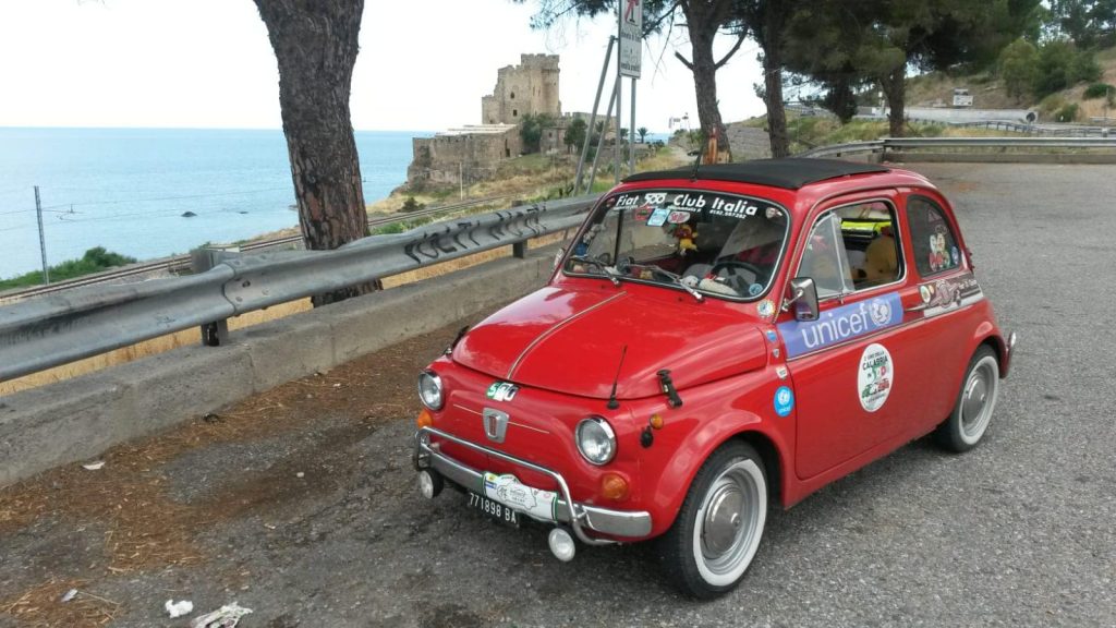 una 500 rossa parcheggiata vicino al mare