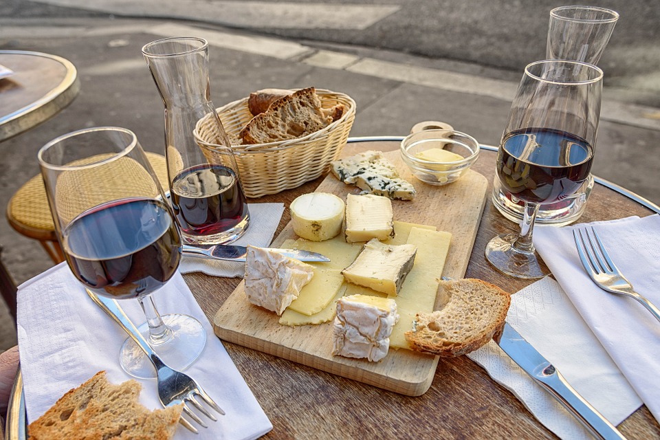Vino Nuovo con i Formaggi e il pane su una tavola imbandita