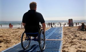 Spiaggia inclusiva - Uomo Su Carrozzina e passerella semovibile