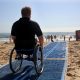 Spiaggia inclusiva - Uomo Su Carrozzina e passerella semovibile