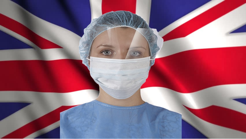 Mercoledì Londra è zona rossa - Mascherina su operatrice sanitaria in Union Jack