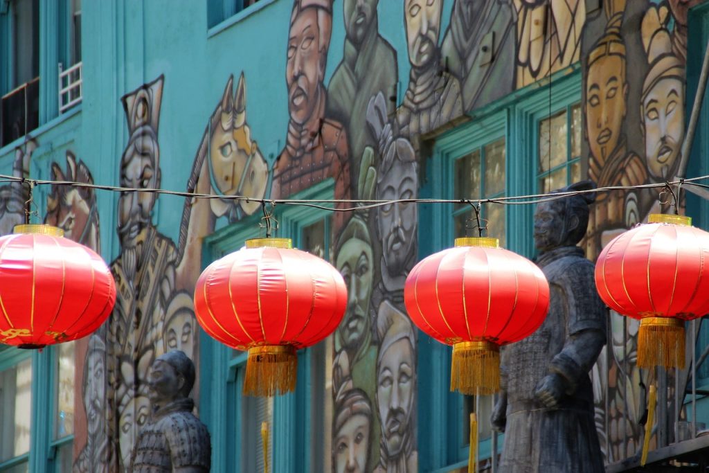 Chinatown di LA. Lanterne Cinesi di colore rosso sul cui sfondo si nota un murales con figure orientali