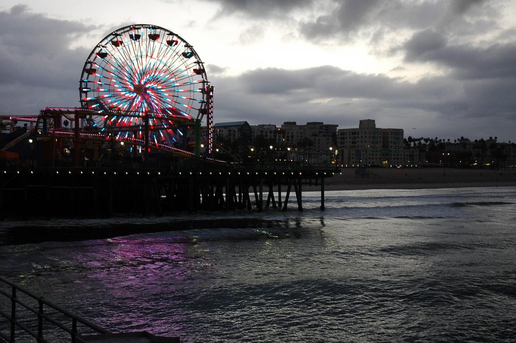 Santa Monica. La colorata ruota panoramica si affaccia sulle sfumature di un cielo e di un mare grigio lungo il molo di S. Monica
