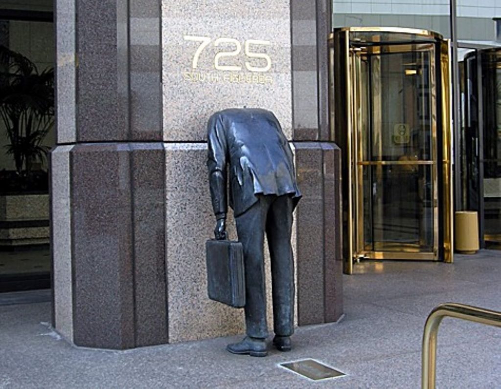 Businessman. Scultura dell'uomo d'affari con testa dentro la parete di un grattacielo