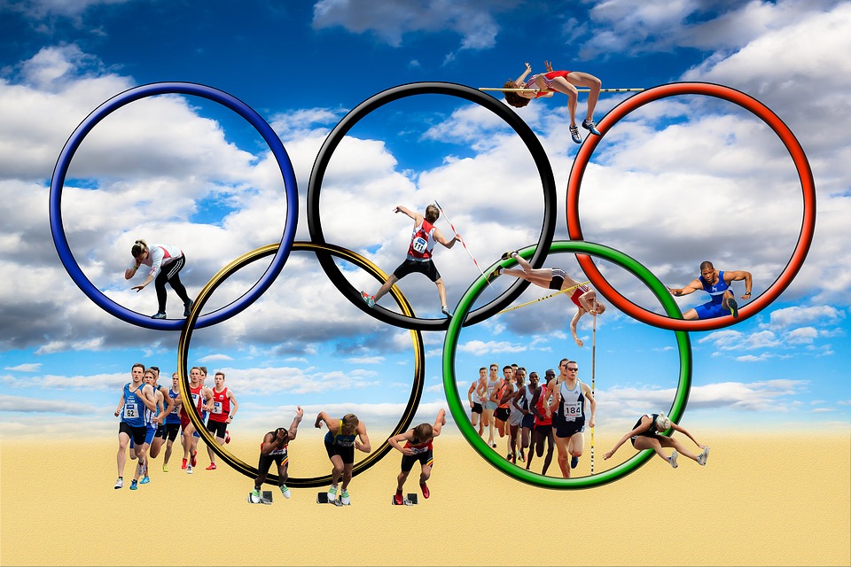 cerchi olimpici stilizzati con atleti impegnati nelle varie discipline
