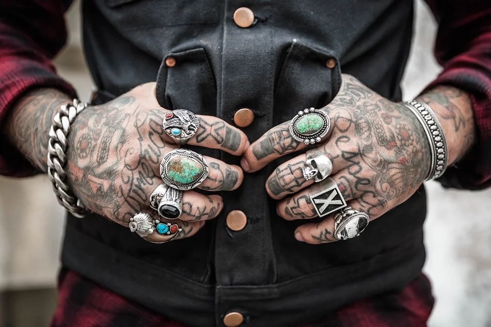 Tattoo convention con le mani di un uomo tutte tatuate