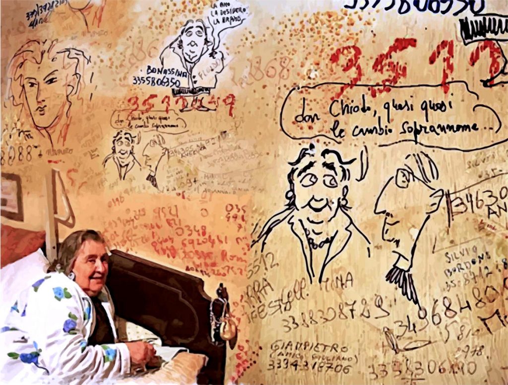Alda Merini seduta sul letto mostra la parete piena di scritte e disegni