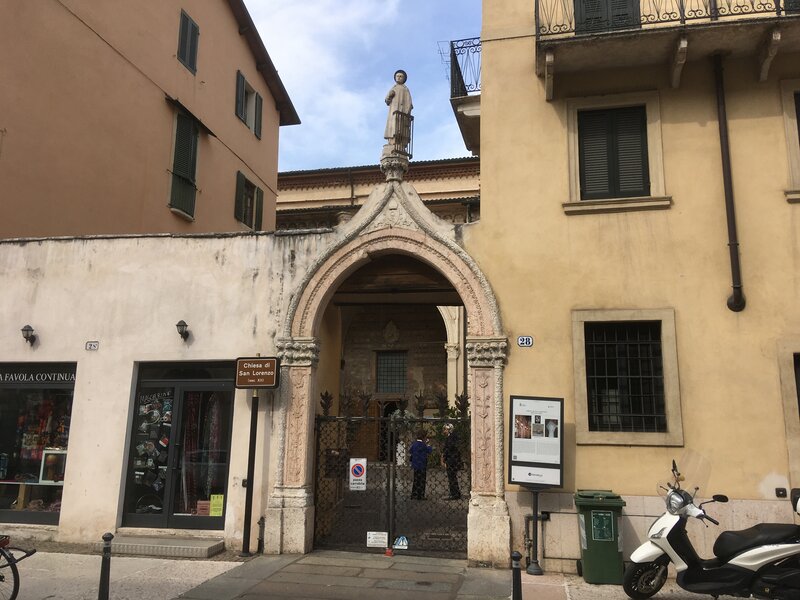 Ingresso San Lorenzo . Cancello ad arco e al centro una statua